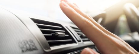 A hand held in front of a car air conditioning vent