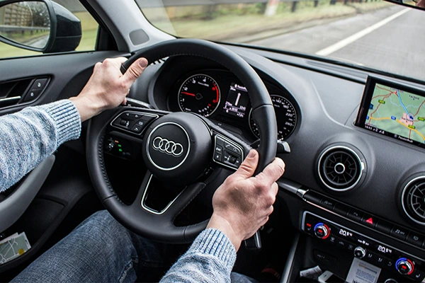 Man holding Audi steering wheel while driving