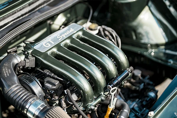 Gunmetal intake manifold on vintage four-cylinder engine