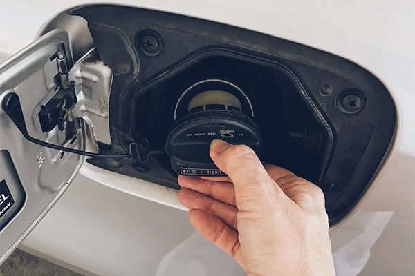 Hand removing gas cap from vehicle