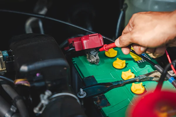 Man checking the output of battery from terminal