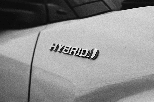 Black and white photo showing hybrid badge on the side of a Toyota vehicle