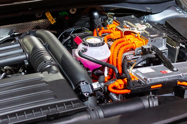 Engine bay of hybrid vehicle showing electric components with orange wiring