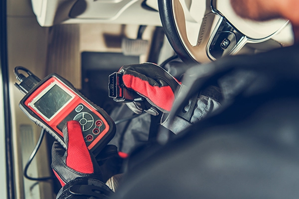 Technician using code reader to diagnose vehicle faults