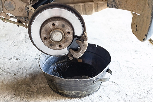 Brake fluid is drained into a basin in the car workshop