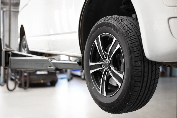 up close look at a suspended vehicle and its front left tire.